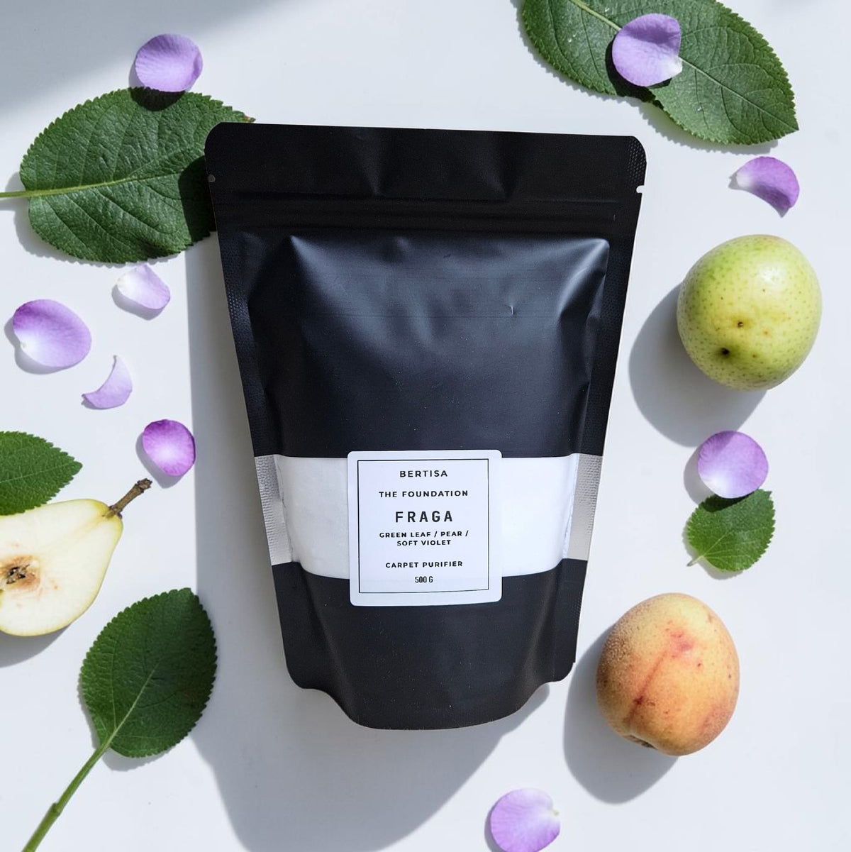 Carpet purifier pouch, black pouch with white label, with fruit and leaves around it