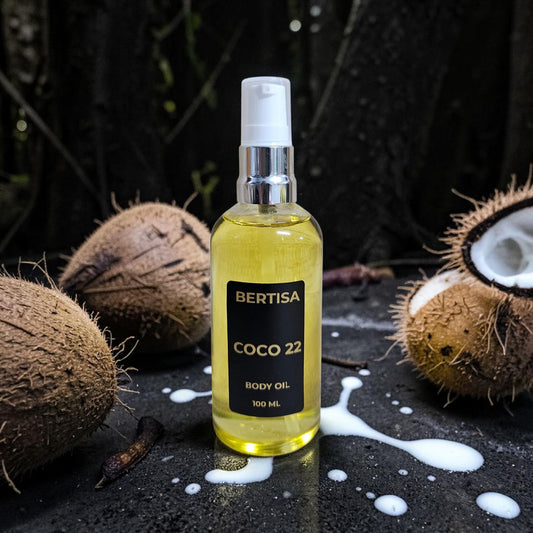 Bottle of Bertisa Coco 22 body oil with coconuts on a dark background