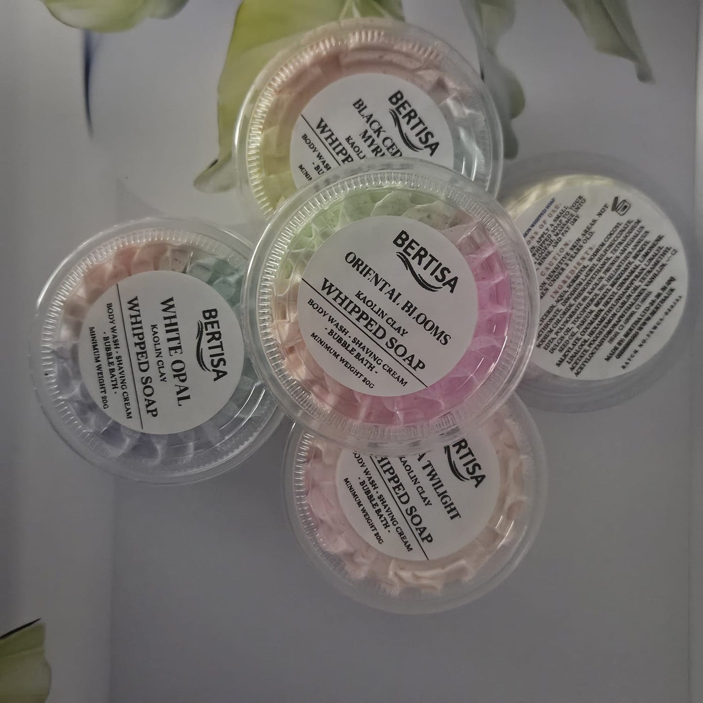 Four containers of Bertisa whipped soap on a white background