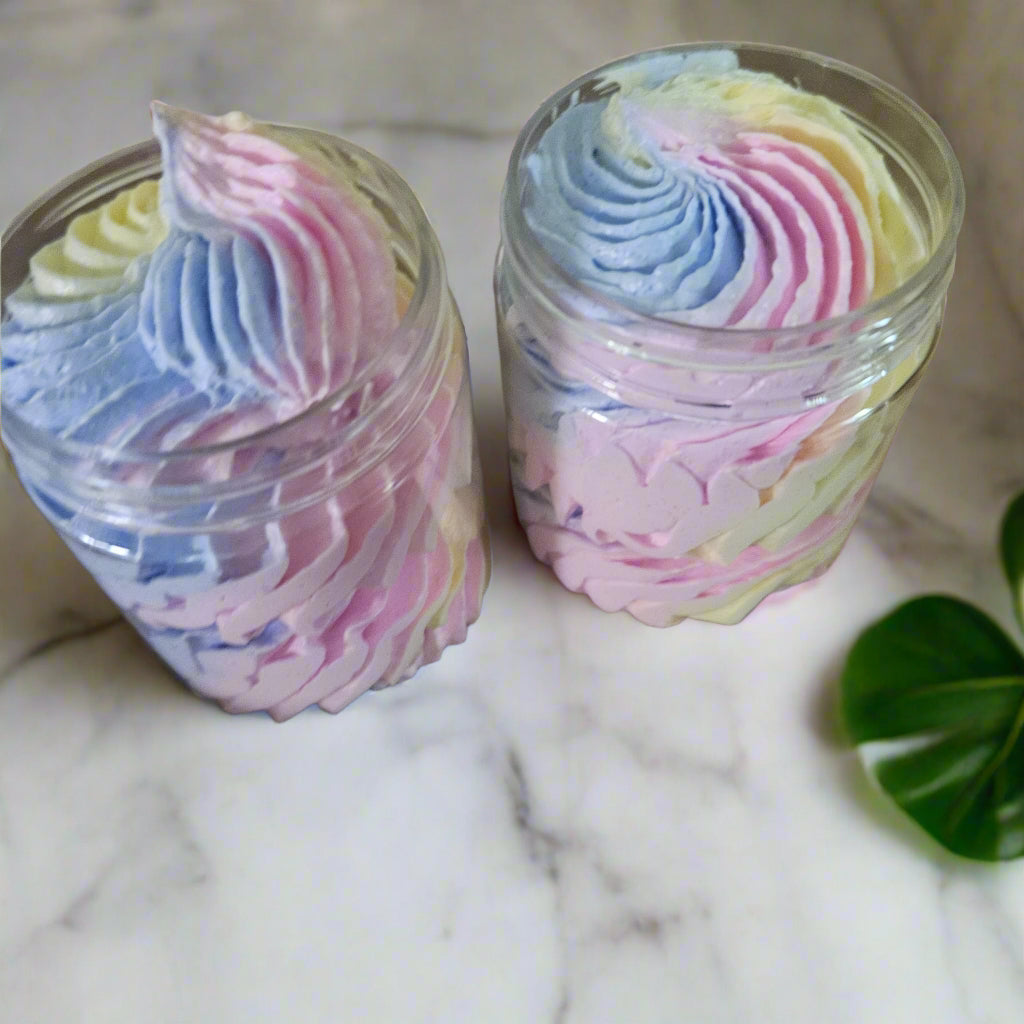 Two glass jars filled with colorful whipped cream on a wooden surface