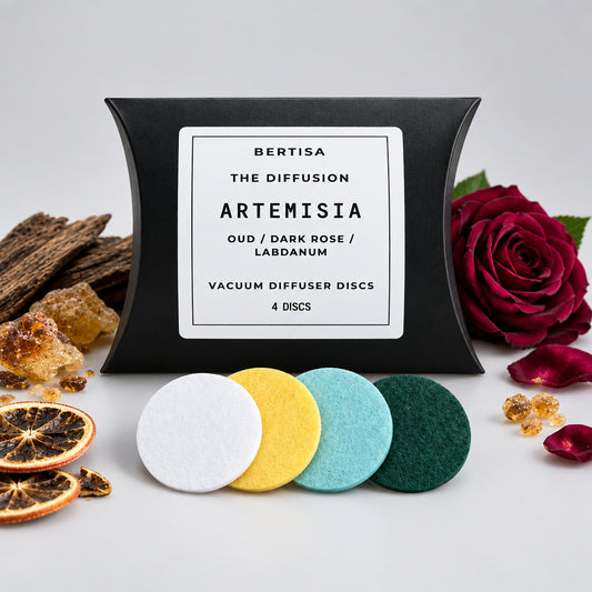 Pack of Bertisa vacuum diffuser discs with Artemisia scent on a wooden surface with flowers and herbs.