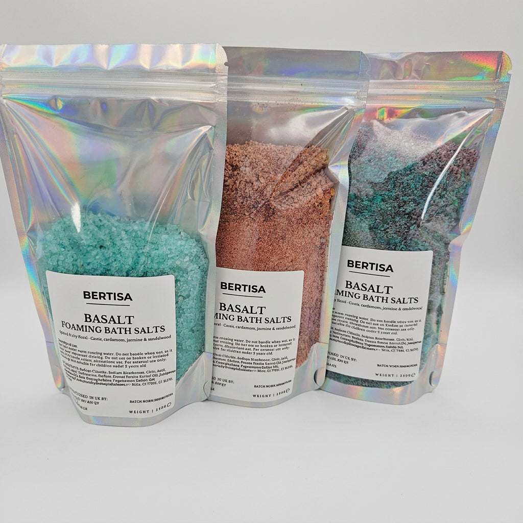 Three stand-up pouches of Bertisa Basalt Bath Salts in different colors (teal, pink, and blue-green) arranged side-by-side on a white background.
