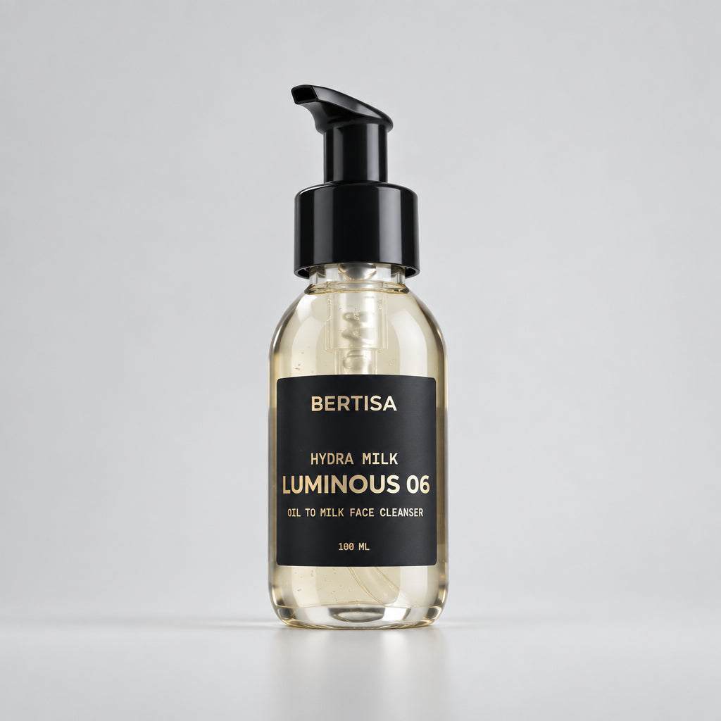 Clear cylindrical pump bottle with golden yellow oil, black dispenser, and matte black label reading Bertisa Hydra Milk