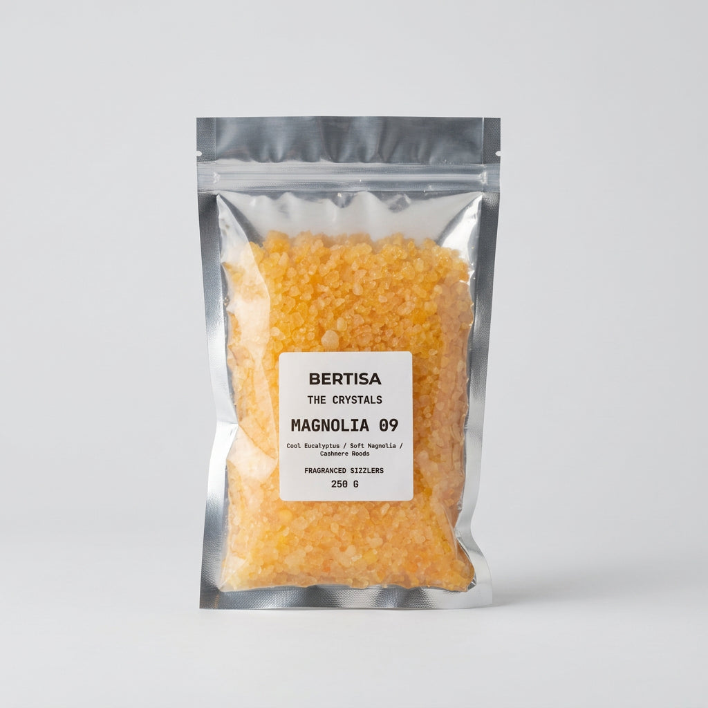Silver resealable bag of Magnolia 09 fragranced sizzlers with yellow-orange crystals, 250g