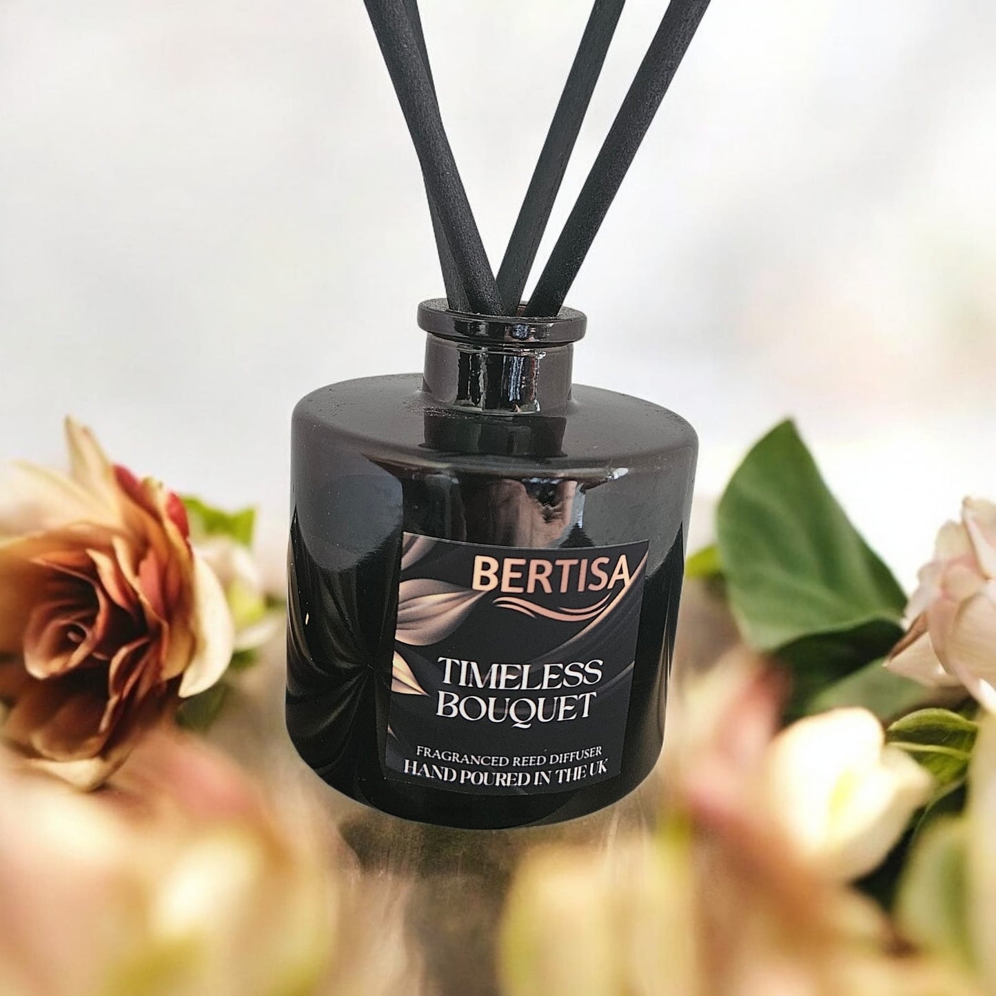 Black Bertisa Timeless Bouquet diffuser with flowers in the background